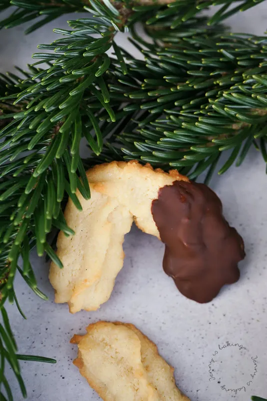 Spritzgebäck-Rohlinge auf Backpapier, mit Spritzbeutel geformt, bereit zum Backen