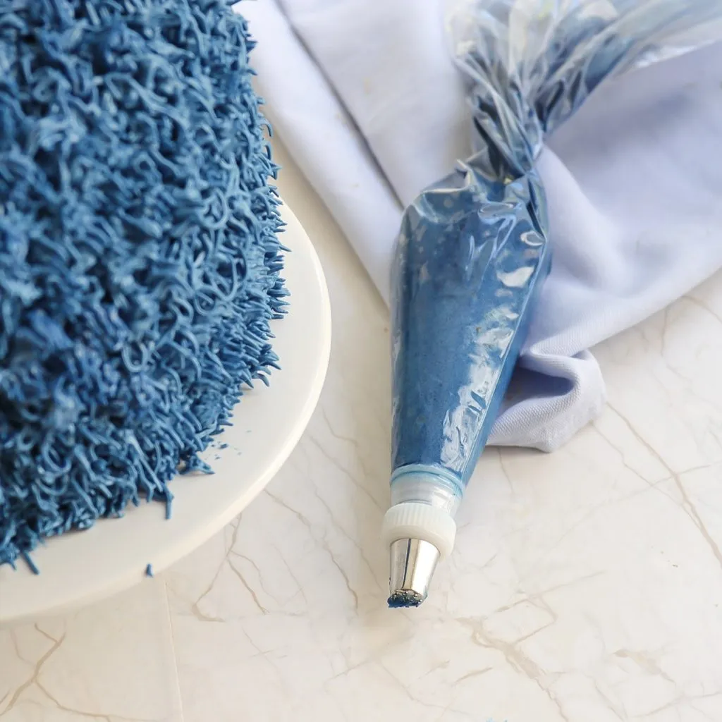 Spritztülle mit Adapter am Spritzbeutel für präzises Dekorieren der Krümelmonster Torte