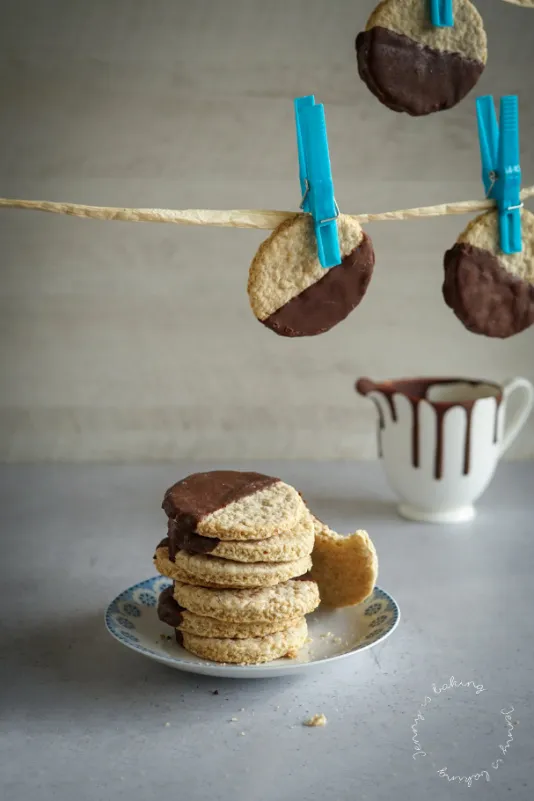 Stapel von knusprigen Haferflockenkeksen, zur Hälfte in dunkle Schokolade getaucht, bereit zum Genießen