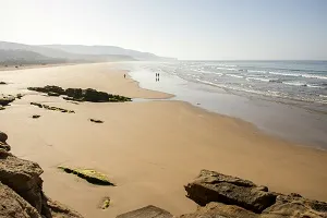 Strandlandschaft in Marokko mit Kamelen am Atlantik, ein kulturell reiches und warmes Reiseziel im Juli.