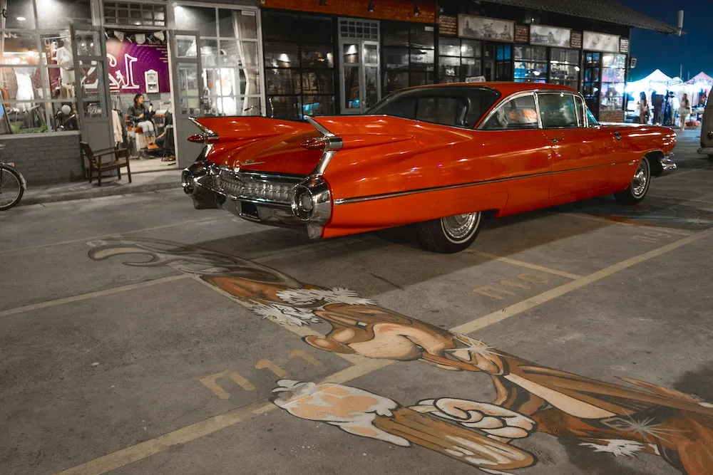 Street Art und antike Autos auf einem Markt – eine Fusion aus Altem und Neuem, die die dynamische Natur der deutschen Getränkekultur, einschließlich Fanta Rot, darstellt.