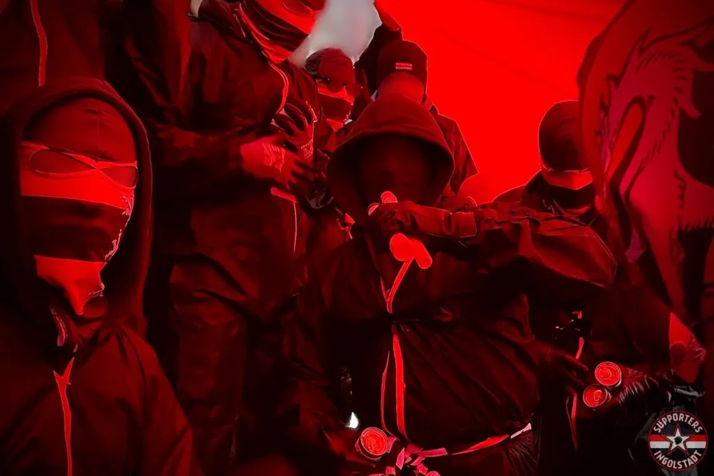 Südtribüne in Ingolstadt mit leuchtenden Fackeln und Rauch vor Anpfiff.