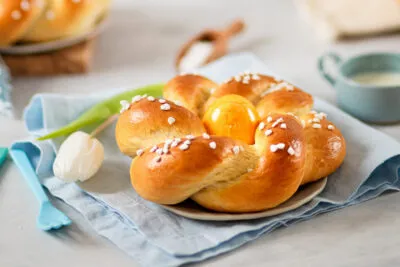 Süßes Osternest mit einem bunten Osterei in der Mitte, auf einem eleganten Teller angerichtet