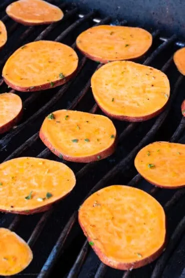 Süßkartoffelscheiben werden auf einem heißen Grillrost goldbraun und knusprig gegrillt.