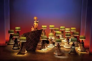 Szene aus dem Musical König der Löwen mit bunten Kostümen auf der Bühne