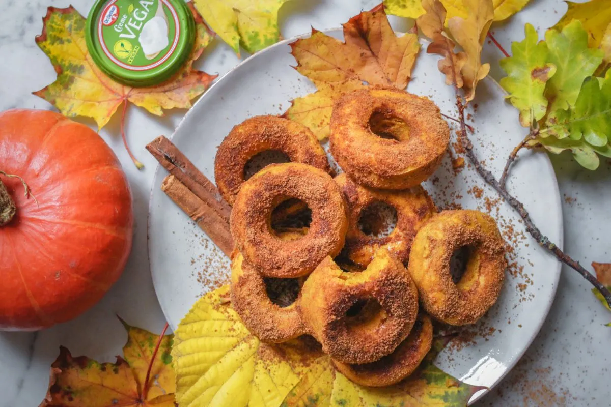 Teller mit veganen Kürbis-Donuts, liebevoll garniert und bereit zum Genießen