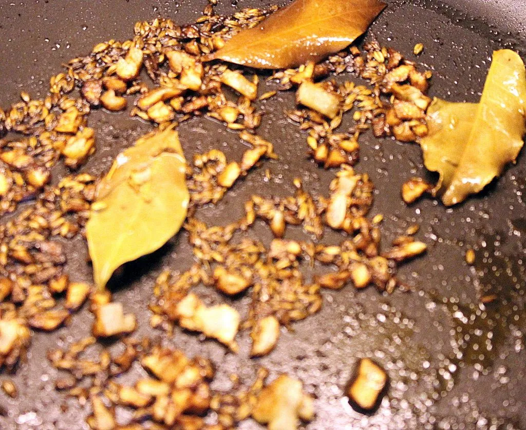 Temperierte Gewürze (Tadka) über gekochte Linsen gießen für intensiven Geschmack