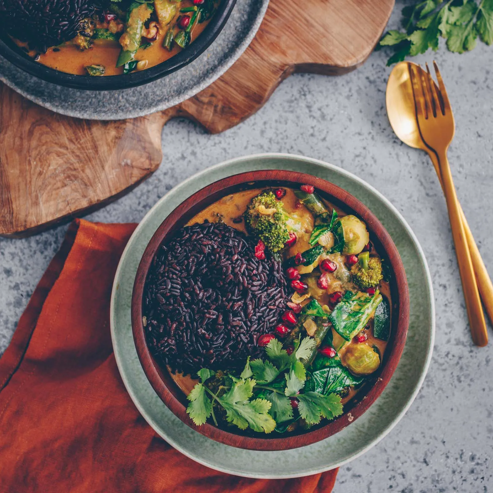 Tiefenaufnahme eines grünen Currys mit knackigem Gemüse und Granatapfelkernen