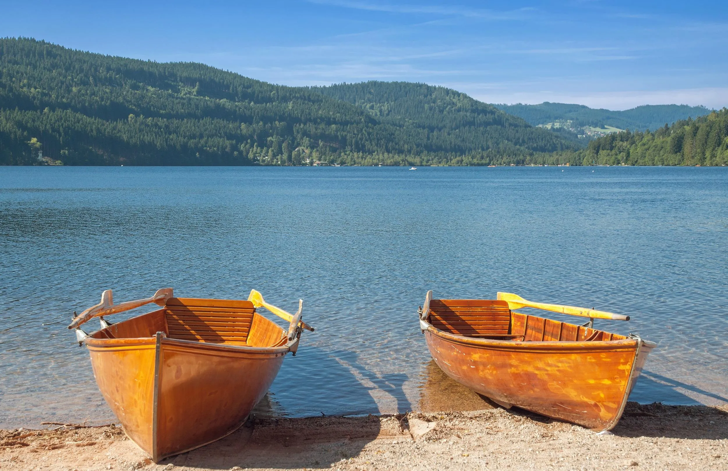 Touristen genießen eine Bootsfahrt auf dem kristallklaren Titisee, einem beliebten Reiseziel im Schwarzwald