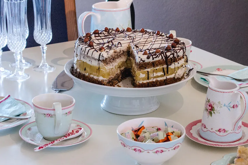 Traditionelle Apfel-Nuss-Sahne-Torte glutenfrei auf festlicher Kaffeetafel