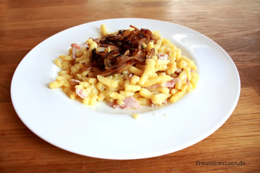 Traditionelle Käsespätzle mit Schinken und Röstzwiebeln, schnell zubereitet