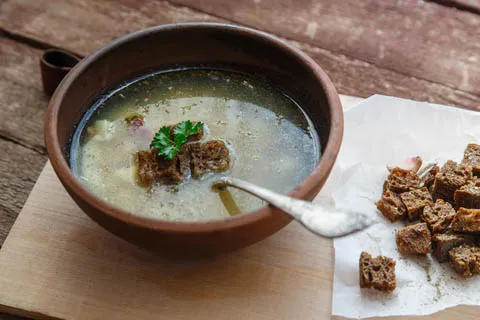 Traditionelle tschechische Knoblauchsuppe Česnečka mit Brotwürfeln