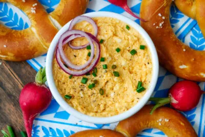 Traditioneller bayerischer Obazda mit frischen Brezen und Radieschen serviert