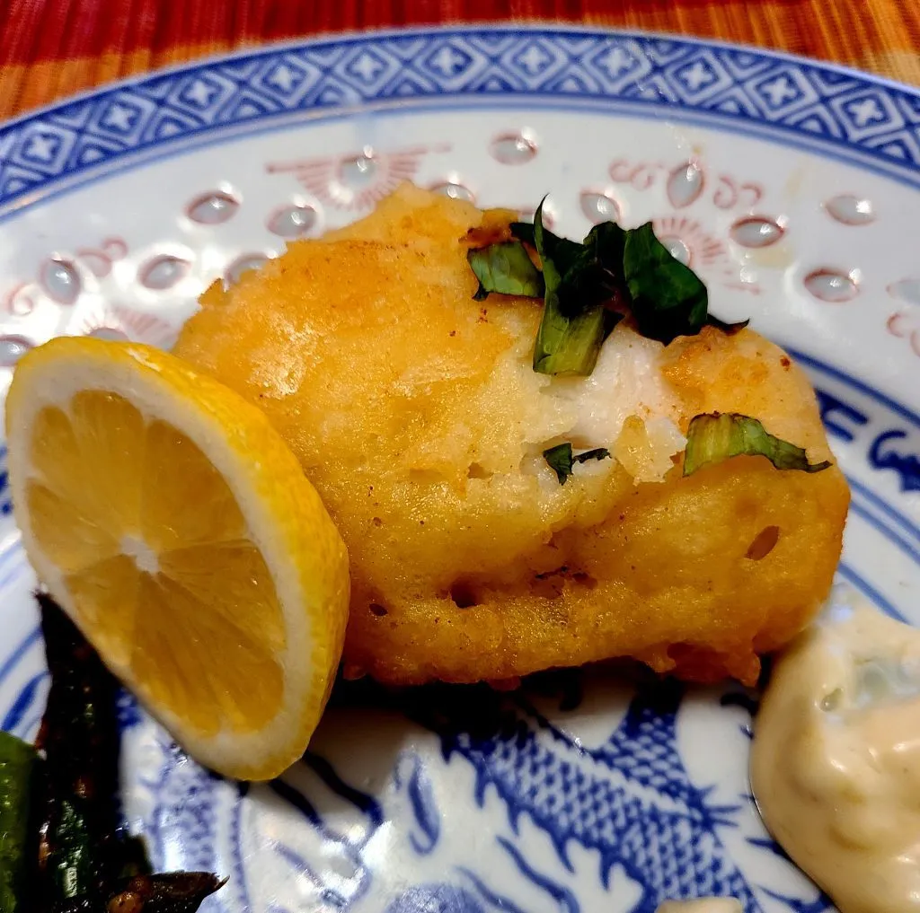 Traditionelles deutsches Fischgericht: Egli im Bierteig als Hauptspeise mit Beilagen auf dem Esstisch