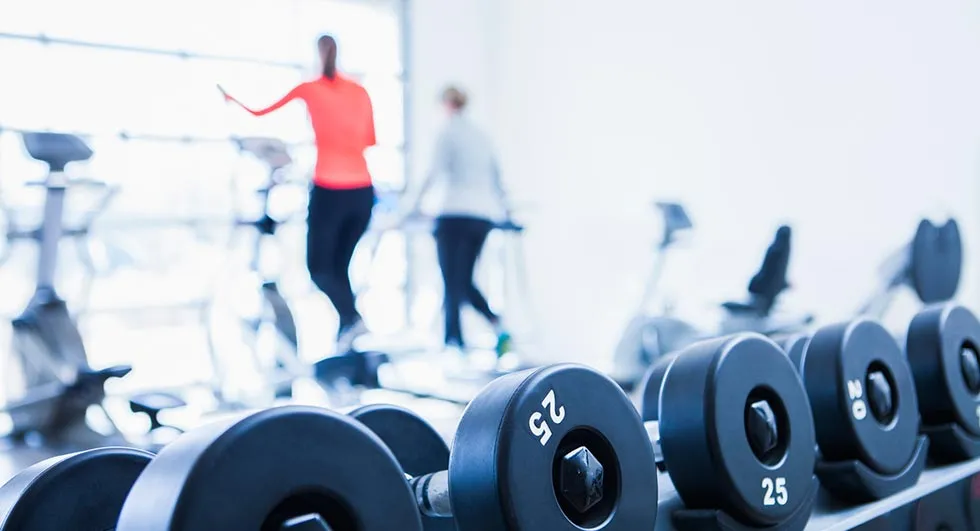 Trainierende Personen in einem modernen Fitnessstudio, das flexible Monatsmitgliedschaften anbietet