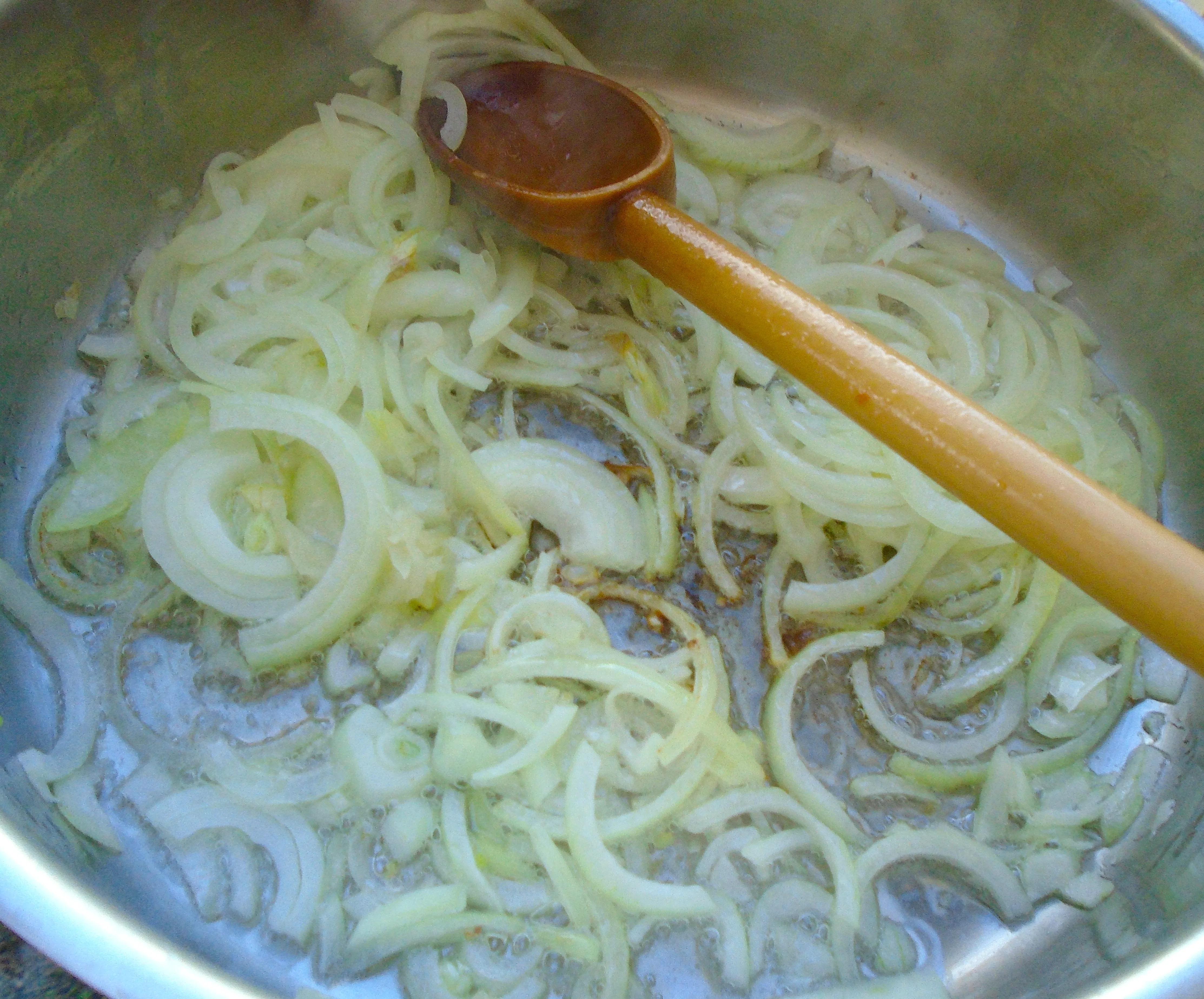 Transparente Zwiebeln in reichlich Schweine- oder Entenfett für das Sauerkraut andünsten