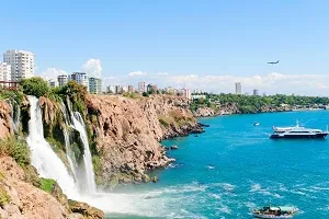 Traumhafter Strand an der Türkischen Riviera bei Antalya mit Sonnenliegen und blauem Meer, perfekt für warme Badeferien im Juli.