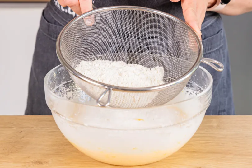 Trockene Zutaten für Pfirsich Joghurt Sahne Torte Teig sieben