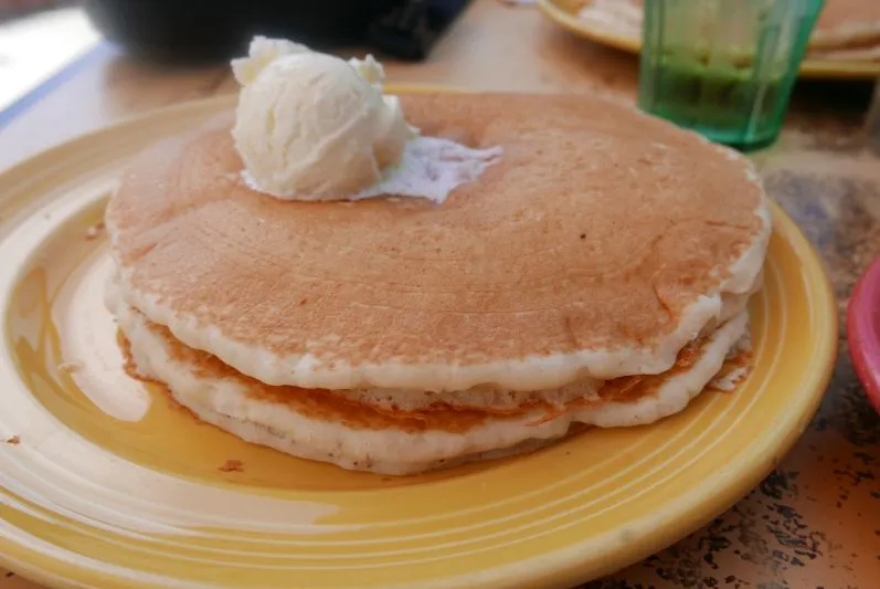 Typisch amerikanische Pancakes mit Ahornsirup und Beilagen, ein süßer Kontrast zur deftigen deutschen Backwarenkultur.