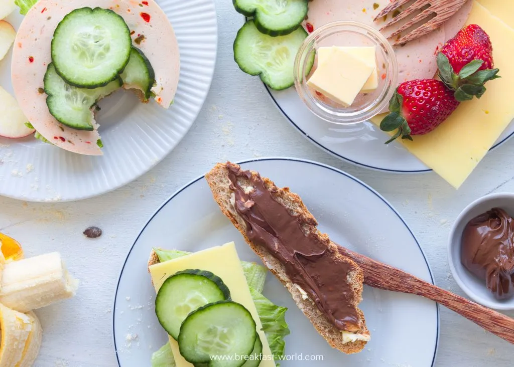 Typisches deutsches Frühstück mit frischen Brötchen, Aufschnitt, Käse und gekochten Eiern.