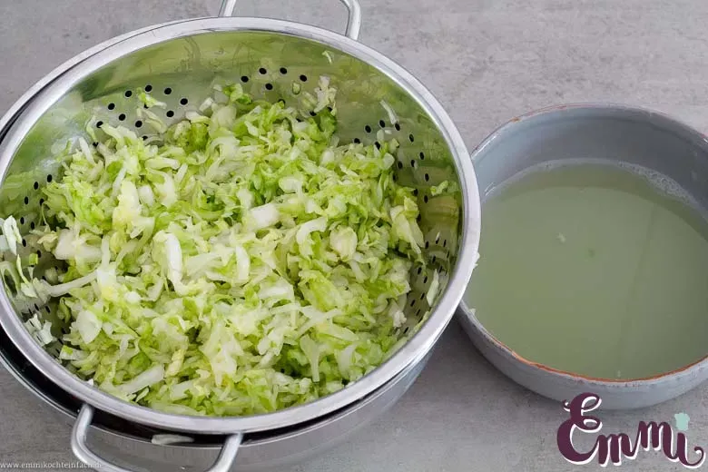 Überschüssige Flüssigkeit aus dem Weißkohl drücken für Cole Slaw
