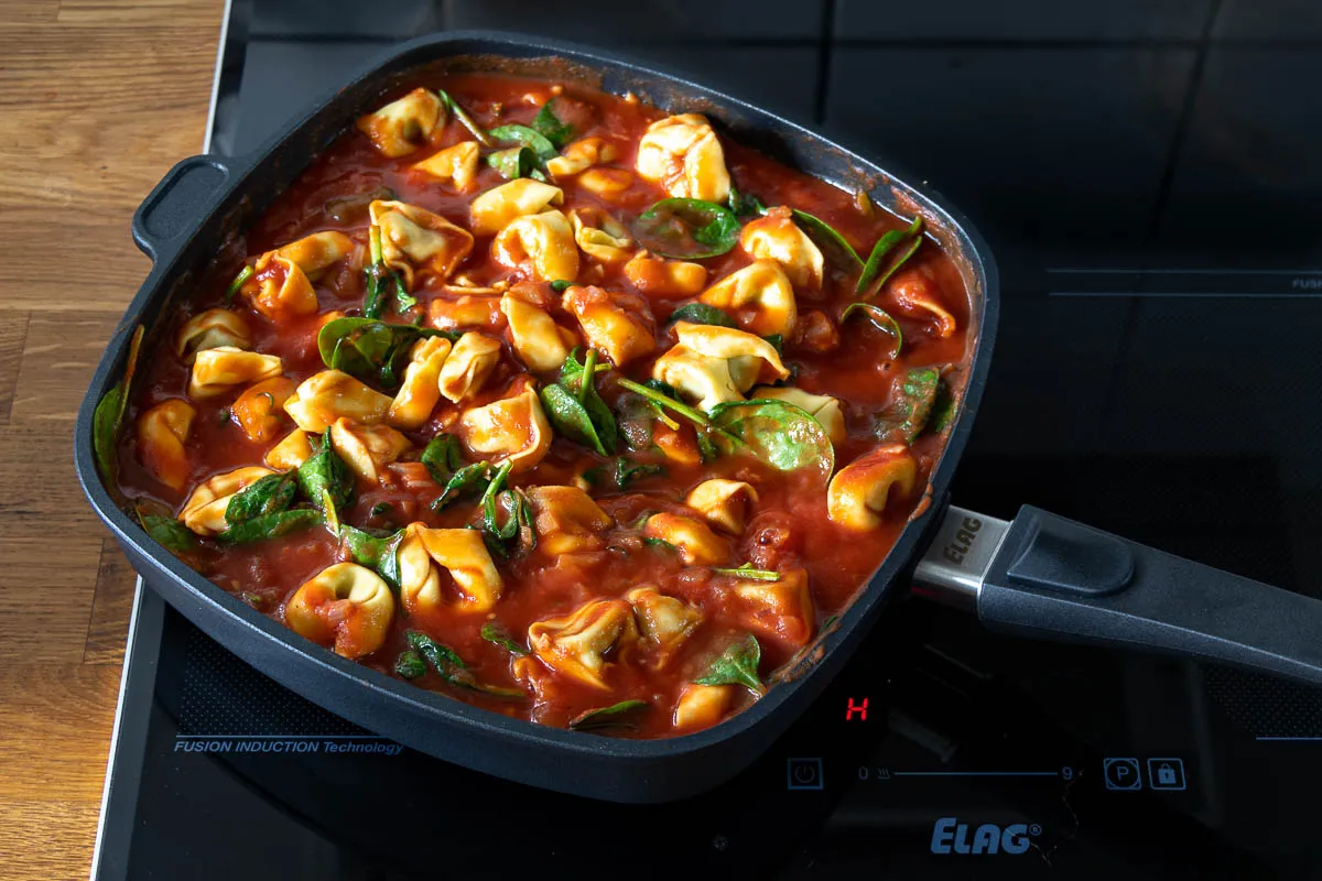 Ungebackener Tortellini Auflauf in der Pfanne, mit Spinat, frischen Tortellini und Mozzarella-Stücken