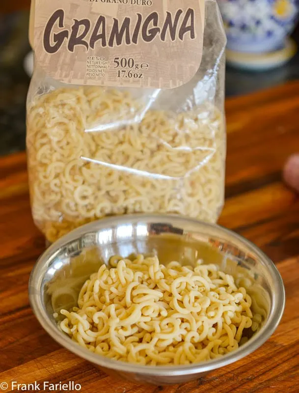 Ungekochte Gramigna-Nudeln, die lockenförmige Pasta, perfekt für Salsiccia-Rezepte