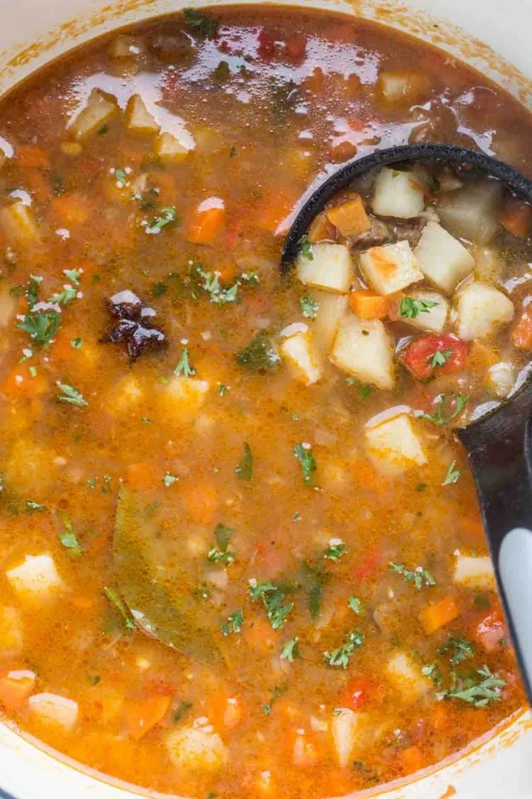 Usbekischer Lagman in einem Schmortopf mit einer Schöpfkelle.