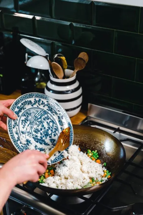 Veganer gebratener Reis mit Tofu-Ei und frischen Kräutern in einer Schüssel, bereit zum Servieren.