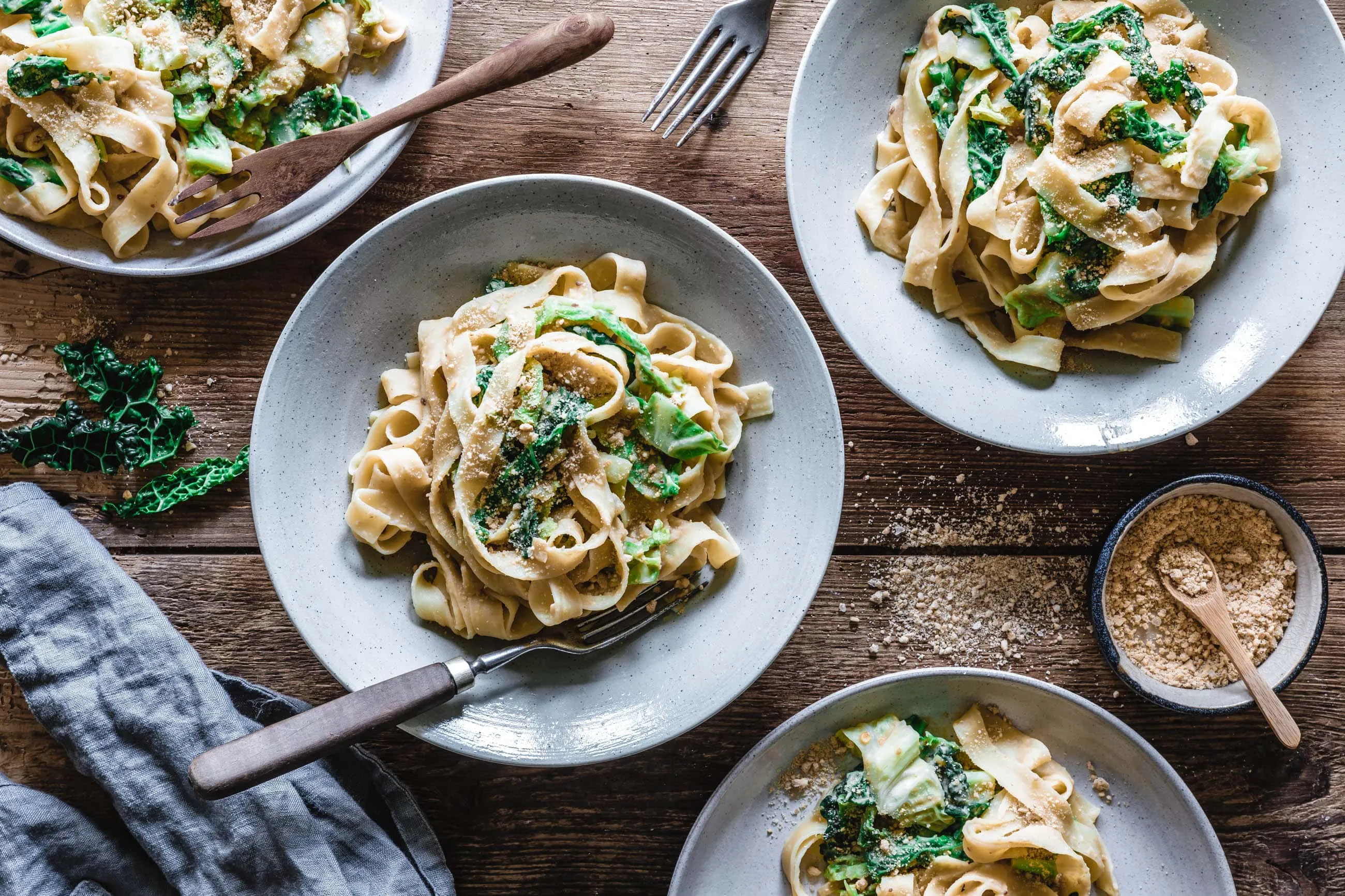 Veganer Wirsing-Pasta-Teller, kunstvoll angerichtet mit frischen Zutaten und der reichhaltigen Hummussauce, ideal für ein gesundes Mittagessen