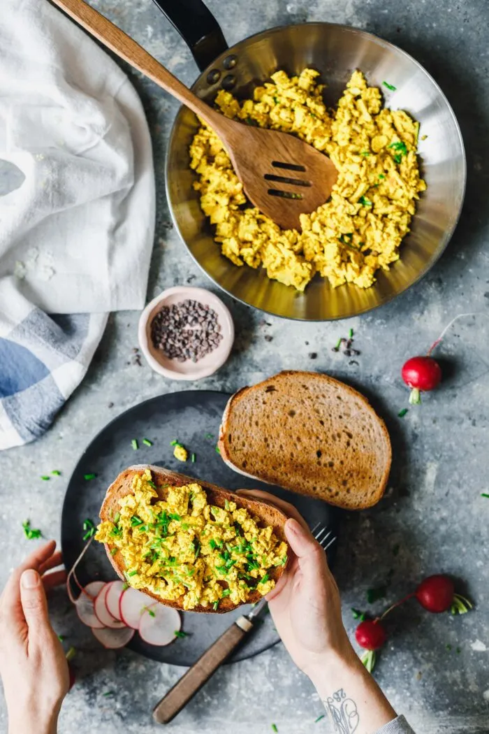 Veganes Rührei aus Tofu mit frischem Schnittlauch auf knusprigem Brot, leicht schlotzig und appetitlich angerichtet.