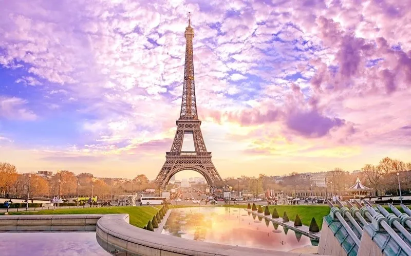 Verliebte küssen sich unter dem Eiffelturm bei Sonnenuntergang in Paris