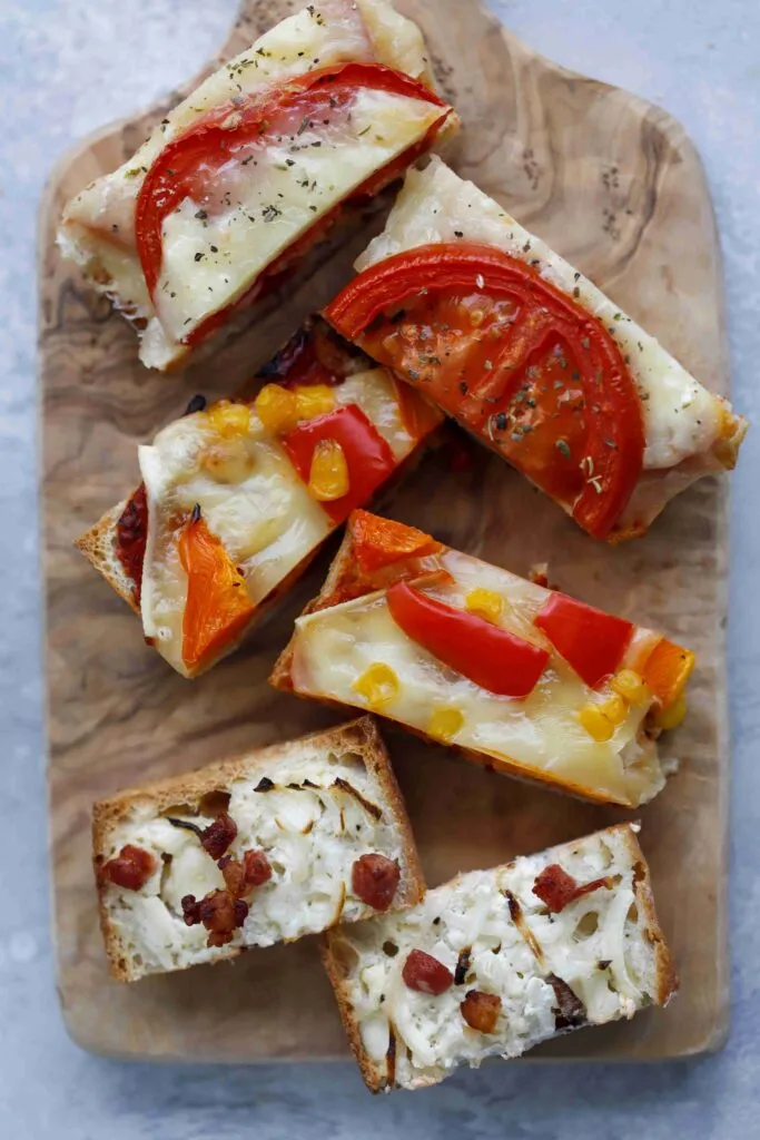 Verschiedene Baguette-Apéros appetitlich auf einer Holzplatte angerichtet