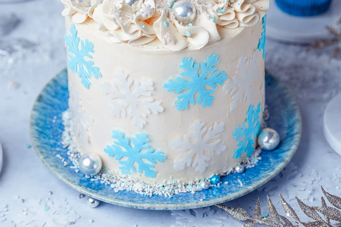 Verschiedene blaue und weiße Streusel und Zuckerperlen als Dekoration auf einer Frozen Torte