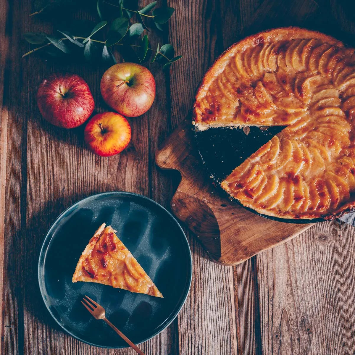 Verschiedene fertige Wähen im Anschnitt, die die unterschiedlichen Schichten von Teig, Äpfeln und Guss zeigen.