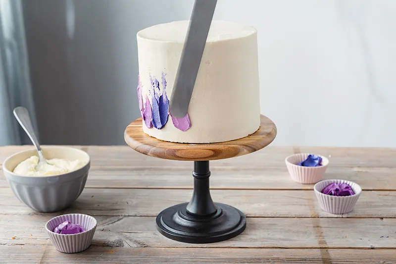 Verschiedene lila Farbnuancen für den Painted Cake Effekt auf die Torte auftragen