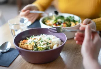 Verschiedene Mehrwegschalen mit Essen zum Mitnehmen auf einem Tisch