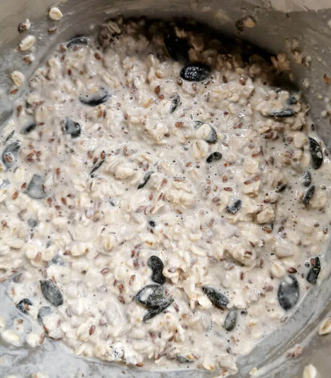 Verschiedene Stadien der Zubereitung von Knäckebrot, von der Vermischung der Zutaten bis zum fertigen Teig, der auf einem Backblech verteilt ist.