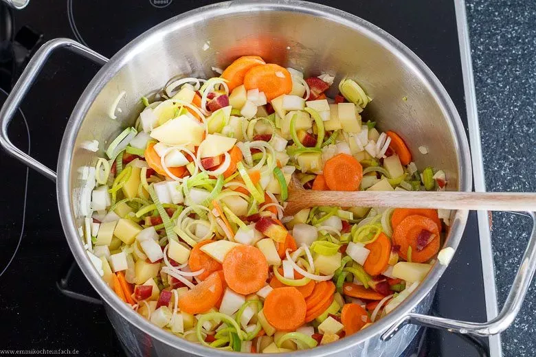 Verschiedenes Gemüse wird im Topf sanft angedünstet, um das volle Aroma für eine köstliche Gemüsesuppe für Anfänger zu entfalten.