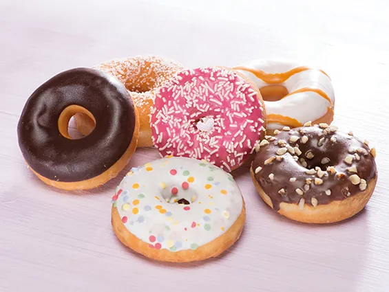 Vielfältige Mini-Donuts mit bunten Glasuren und Streuseln, präsentiert als moderne süße Leckerei für jede Gelegenheit.