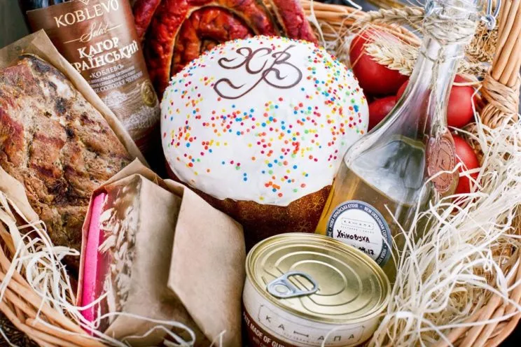 Vielfältige ukrainische Gerichte auf einem rustikalen Holztisch, darunter Borschtsch und Wareniki, präsentieren die reiche Esskultur der Ukraine.