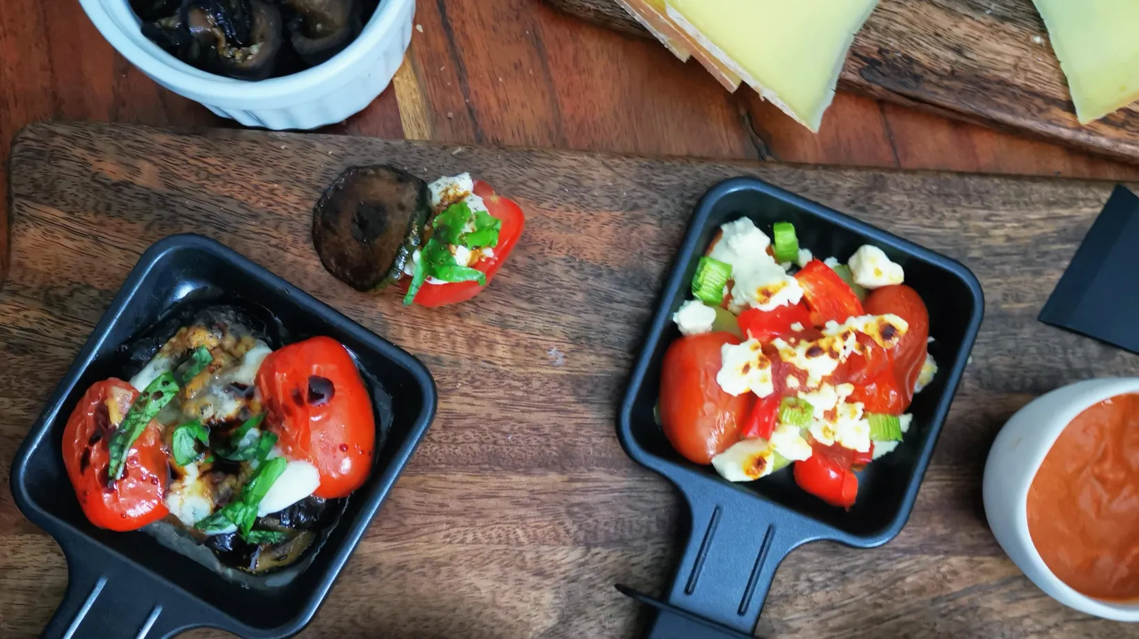 Vielfältige vegetarische Raclette-Pfännchen mit Brokkoli, Paprika und geschmolzenem Käse