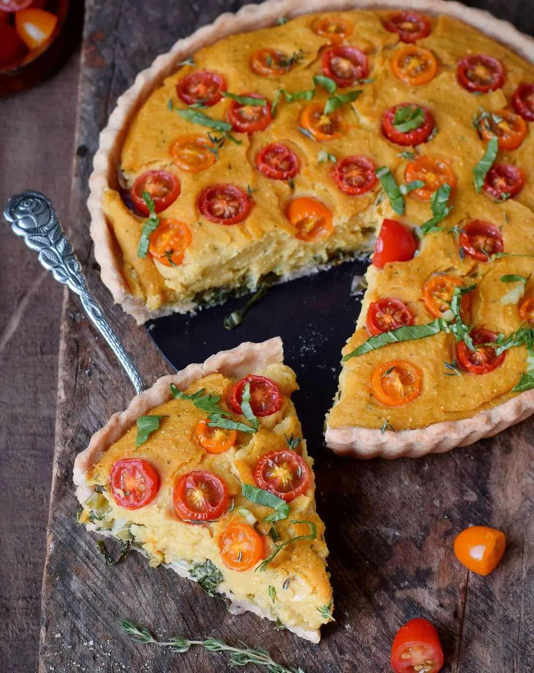 Vielseitige vegane Quiche mit Kichererbsenmehl-Füllung und dekadentem Teig, serviert mit einem Stück im Vordergrund, ideal für das Mittagessen.