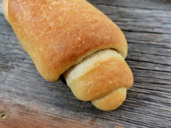Vier goldbraun gebackene italienische Brötchen Panini, frisch aus dem Ofen auf einem Backblech