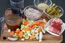 Vorbereitete Zutaten für das Rouladen Rezept: Zwiebeln, Gurken, Senf und Speck bereit zum Füllen der Rinderroulade.