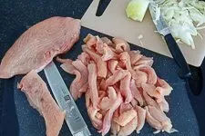 Vorbereitetes Putenschnitzel und Zwiebelstreifen, bereit für die Gyros-Marinade nach Rezept