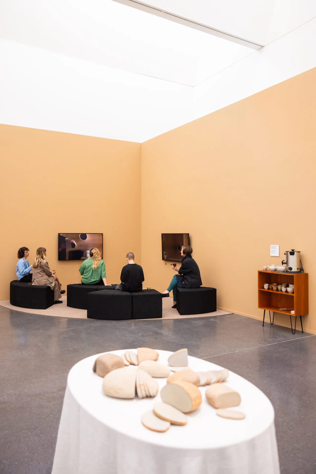 Während die Besucher*innen Gerstentee trinken dürfen, können sie sich die Videoarbeit von Iden Sungyoung Kim anschauen.