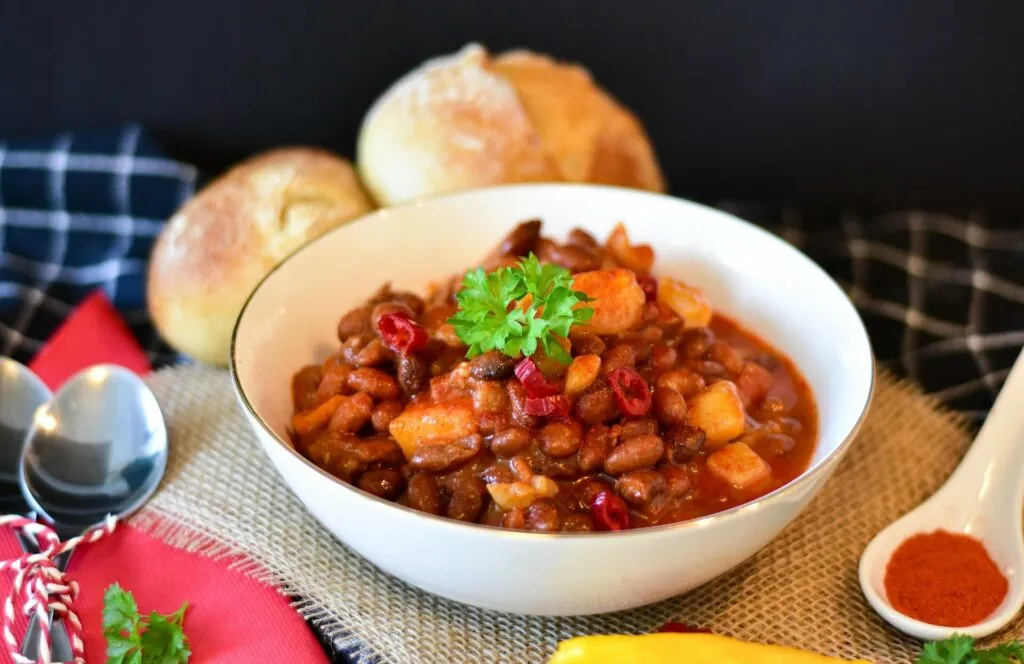 Wärmender Chili con Carne Eintopf mit frischer Petersilie, ein feuriges und sättigendes Campinggericht für kühle Abende.