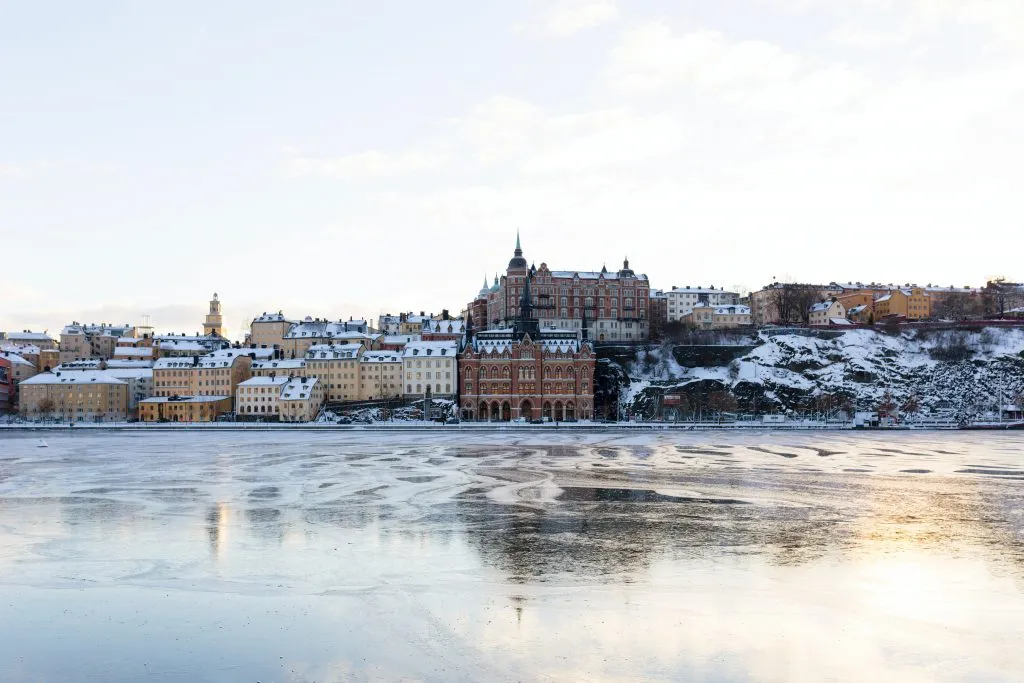 Winterliche Skyline von Stockholm vom Wasser aus betrachtet, mit beleuchteten Gebäuden
