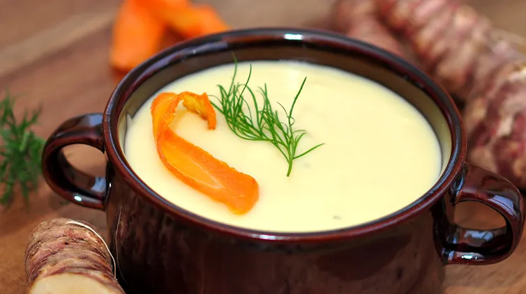 Wintersuppen: Topinambursuppe mit Curry, Karotte und frischen Gewürzen in einer rustikalen Schale.